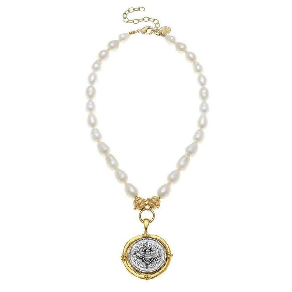 Elegant pearl necklace featuring a gold bee coin pendant.