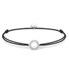 Black cord bracelet with a circular, silver charm adorned with sparkling stones.