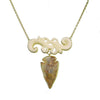Carved Flur Amber Arrowhead necklace: gold chain, carved bone accents, and a unique amber arrowhead pendant.
