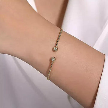 14K gold split cuff bracelet adorned with diamond accents.
