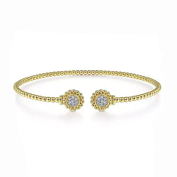 Gold beaded bangle bracelet featuring pave diamond accents.
