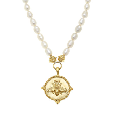 Handcast gold bee pendant on a necklace featuring white freshwater pearls and a textured round coin design.