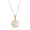 Angel in Flight necklace: silver coin pendant with engraved bird, gold accents & diamonds, delicate chain.
