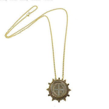 Gold chain necklace with antique coin pendant featuring a cross.
