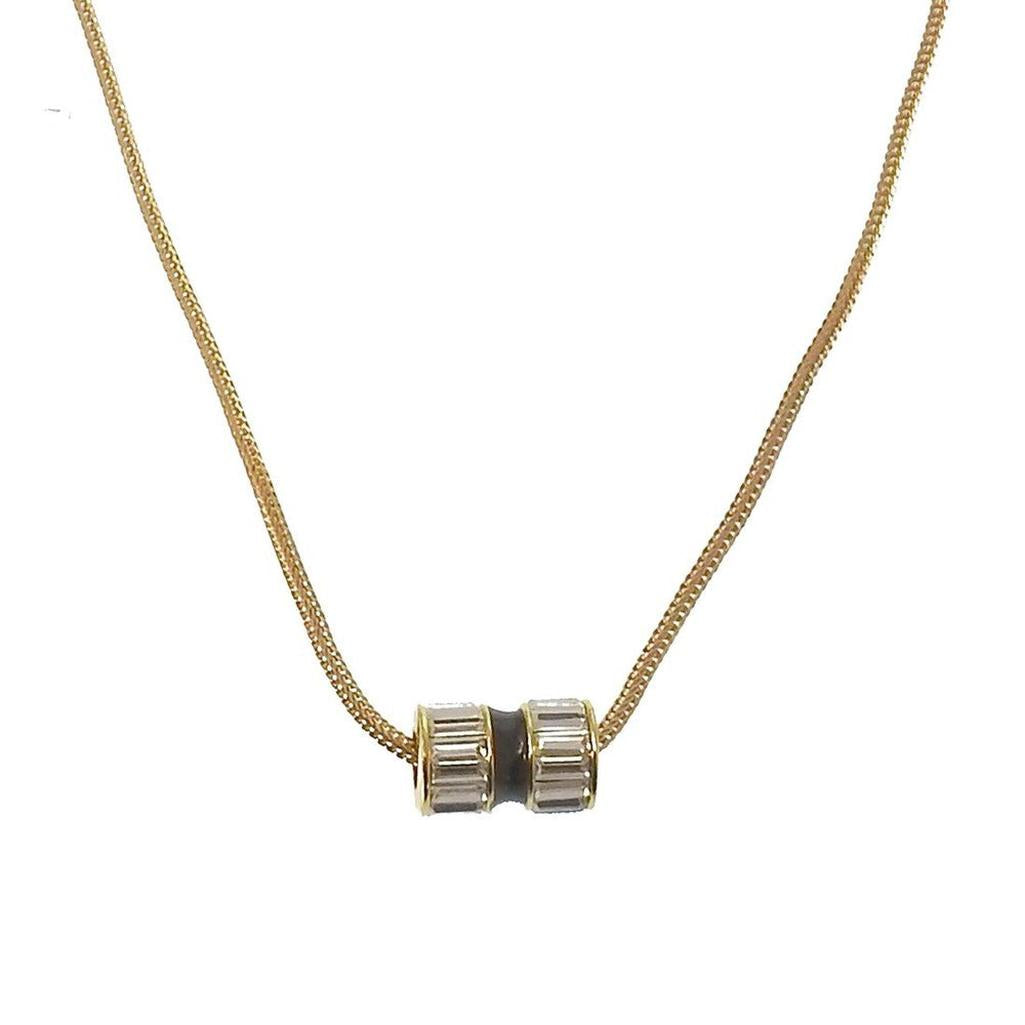 Gold chain necklace with barrel pendant featuring clear crystals.

