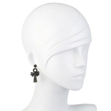 Dark grey tassel earrings on a mannequin, featuring a circular accent.

