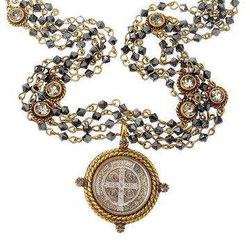 Multi-strand hematite necklace with gold accents and a detailed circular pendant.

