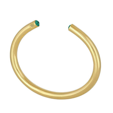 Gold bangle bracelet featuring emerald green gemstones.

