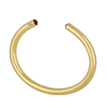 Gold bangle bracelet with small red gemstone accents.
