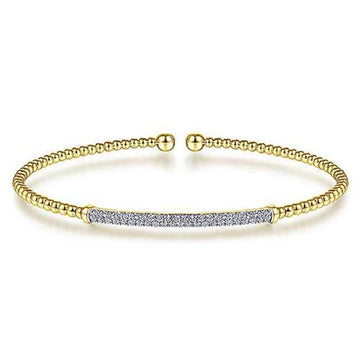 Yellow gold beaded cuff bracelet featuring a pave diamond bar.
