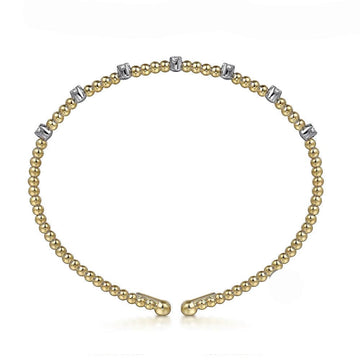 Yellow gold beaded bracelet adorned with small diamonds.
