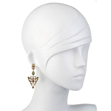 Gold butterfly earrings with pink and green gemstones dangling from a mannequin's ear.
