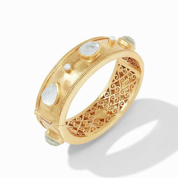 Gold statement bangle with moonstone and pearl accents, featuring an intricately designed open back.
