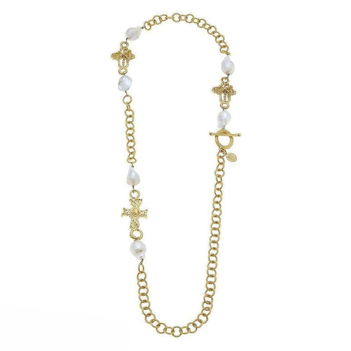 Gold chain necklace with baroque pearls and ornate cross charms.
