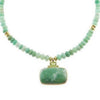Necklace with green beads and a large green stone pendant on a white background