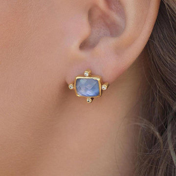 Gold stud earrings featuring a lavender gemstone and small diamonds.

