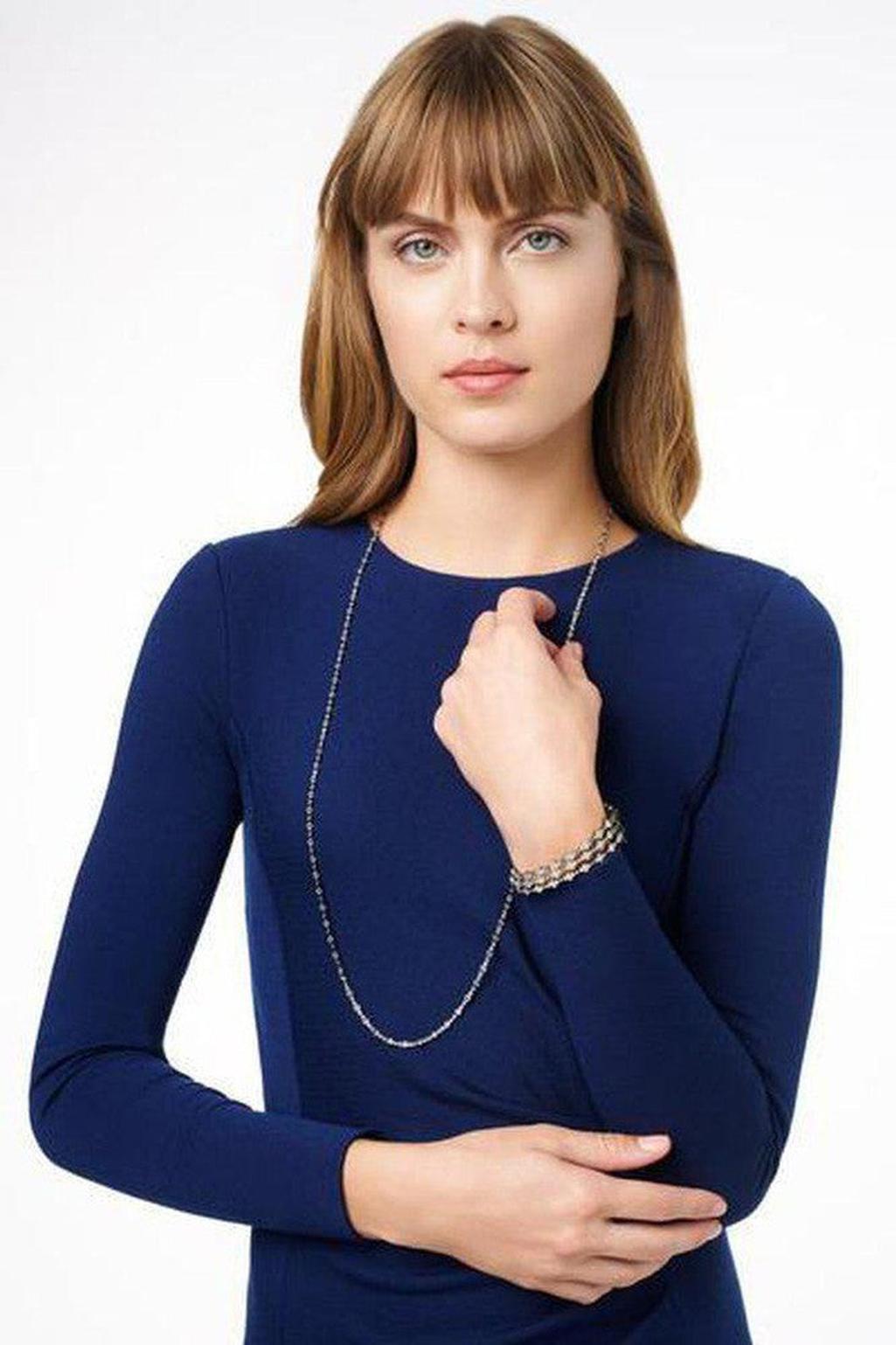 Silver hinged bangle bracelet on a model wearing a navy dress.
