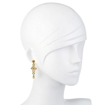 Gold cross dangle earrings with pearl detail on a mannequin.
