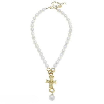 Gold cross pendant necklace on a pearl strand; elegant, faith-inspired jewelry.
