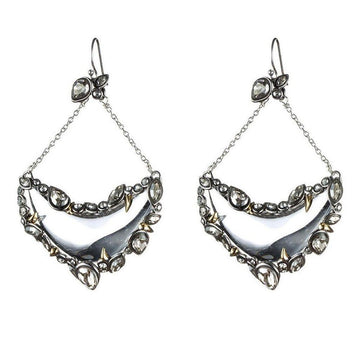 Silver crescent earrings with crystals and gold accents; statement jewelry.
