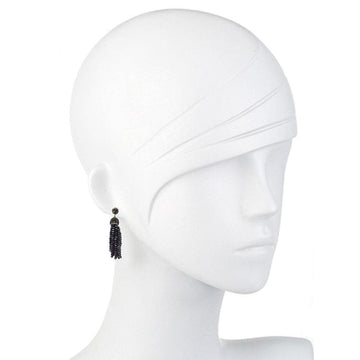 Dark crystal tassel earrings on a white mannequin.
