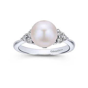 Elegant white gold ring featuring a cultured pearl and diamond accents.
