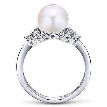 Elegant pearl ring featuring a large cultured pearl and delicate diamond accents.
