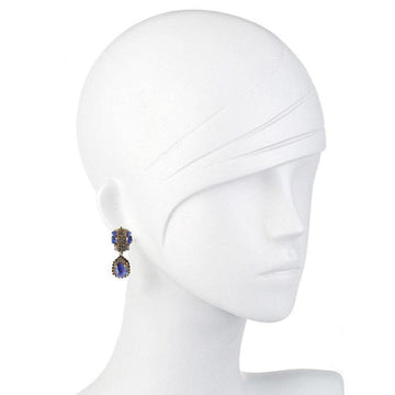 Sapphire and gold drop earrings on a mannequin.
