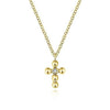 Delicate yellow gold cross necklace with a single diamond accent.
