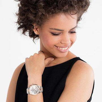Rose gold and silver chronograph watch on a model's wrist.
