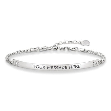 Silver ID bracelet with engraved message space, delicate chain, and small accents.
