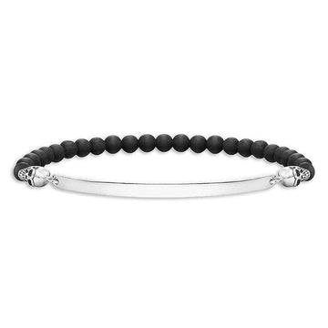 Engravable black onyx bead bracelet with silver skull accents and ID plate.
