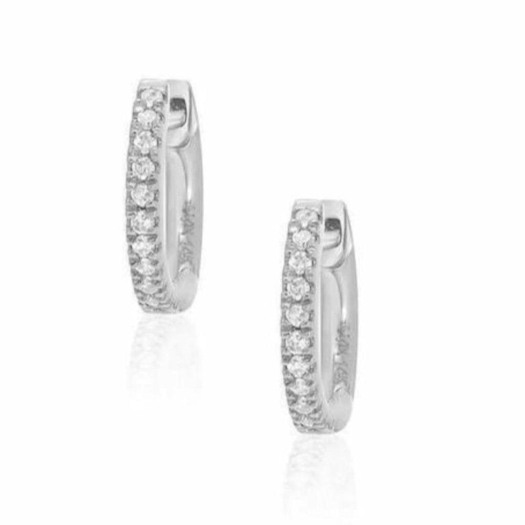 Petite diamond huggie earrings in silver, featuring a dazzling row of sparkling stones.
