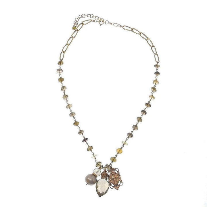 Faceted quartz and pearl necklace with Madonna charm, gold chain, on white background
