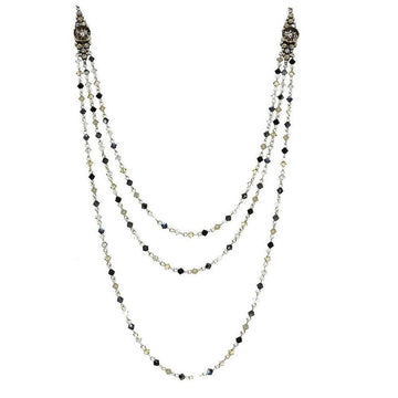 Three-strand crystal necklace with dark and light gray beads, silver chain, and ornate accents.
