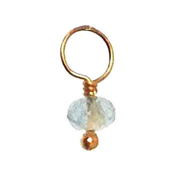 Delicate gold charm featuring a pale blue gemstone accent.
