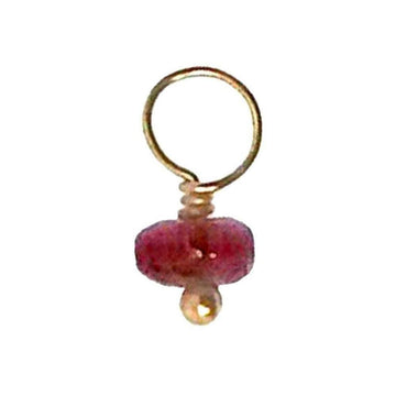 Pink gemstone charm with gold wire accents.
