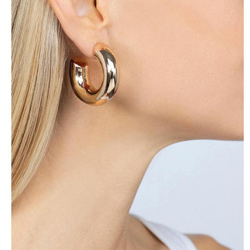 Gold medium hoop earrings worn by a model.
