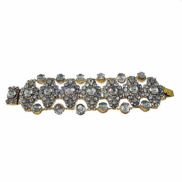 Gold bracelet adorned with sparkling clear stones, arranged in an intricate floral pattern.
