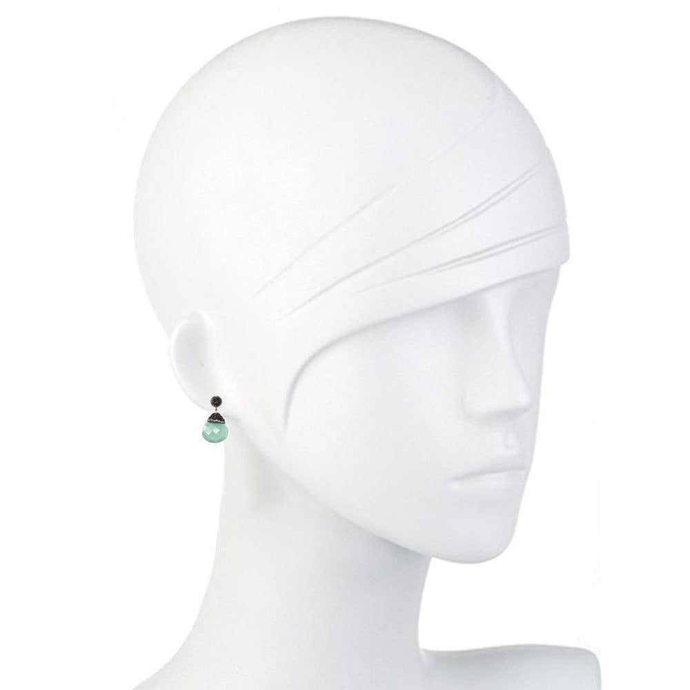 Elegant teardrop hematite earrings with a pale green stone, shown on a mannequin.
