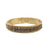 Gold hinged bangle bracelet with dark crystal accents.
