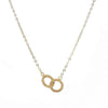 Gold infinity necklace with delicate chain and textured interlocking circles.
