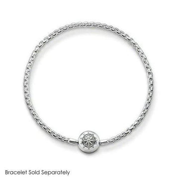 Silver lotus charm with detailed design, on a delicate chain bracelet.
