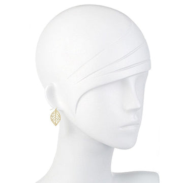 Gold leaf-shaped earrings on a mannequin.
