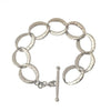 Silver link bracelet with hammered texture and toggle clasp.
