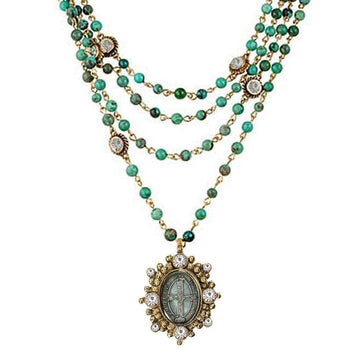 Multi-strand turquoise bead necklace with gold accents and a detailed pendant.
