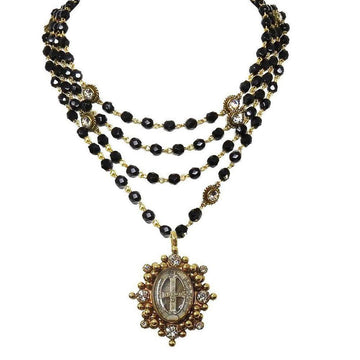 Multi-strand black beaded necklace with gold accents and a detailed antique pendant.
