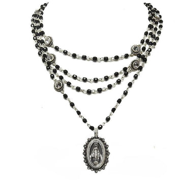 Layered black beaded necklace with silver accents and a Madonna medallion pendant.
