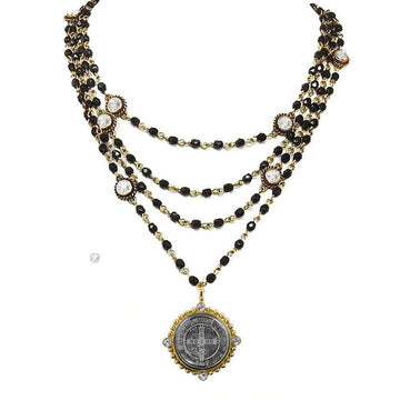 Layered black bead necklace with gold accents and a St. Jude medal pendant.
