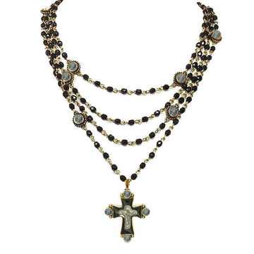 Multi-strand necklace featuring black beads, gold accents, and a cross pendant.
